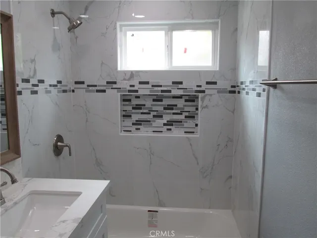 a bathroom with a granite countertop sink a toilet and bathtub