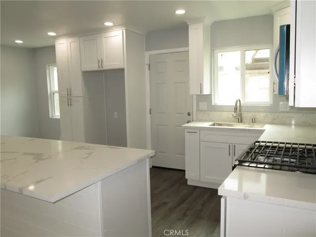 a kitchen with a sink a stove and cabinets