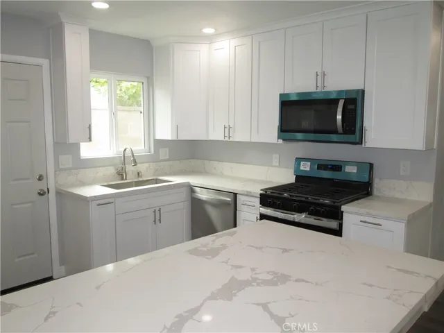 a kitchen with a sink stove and microwave