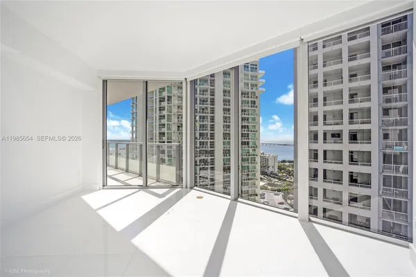 a view of a living room with a balcony and floor to ceiling window