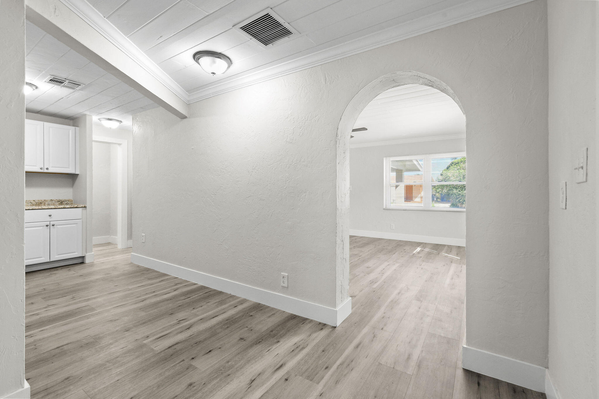 1301 West 25th Street Riviera Beach, FL 33404 - Photo 12 of 34 an empty room with wooden floor cabinet and windows