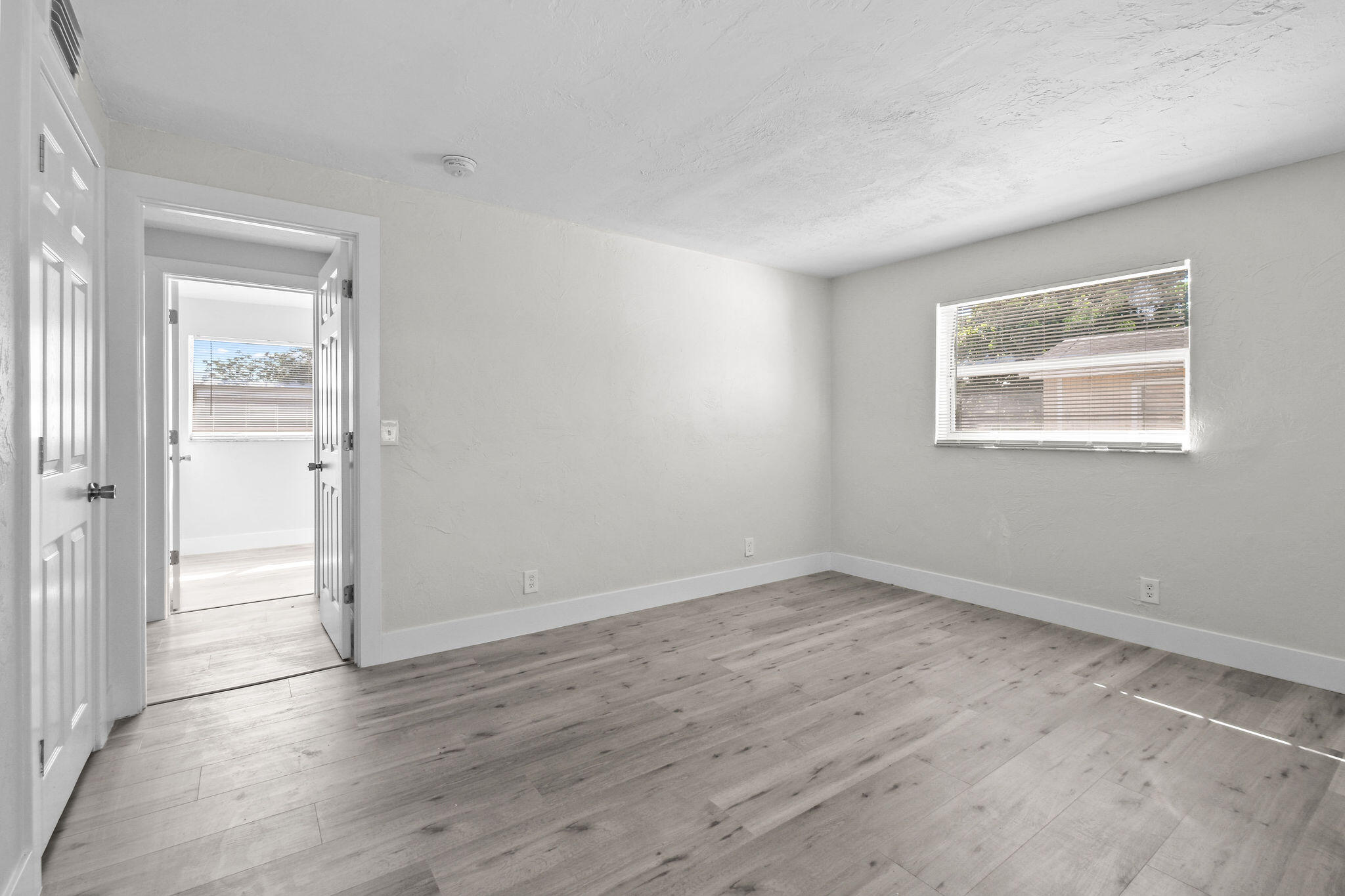 1301 West 25th Street Riviera Beach, FL 33404 - Photo 15 of 34 an empty room with wooden floor and windows
