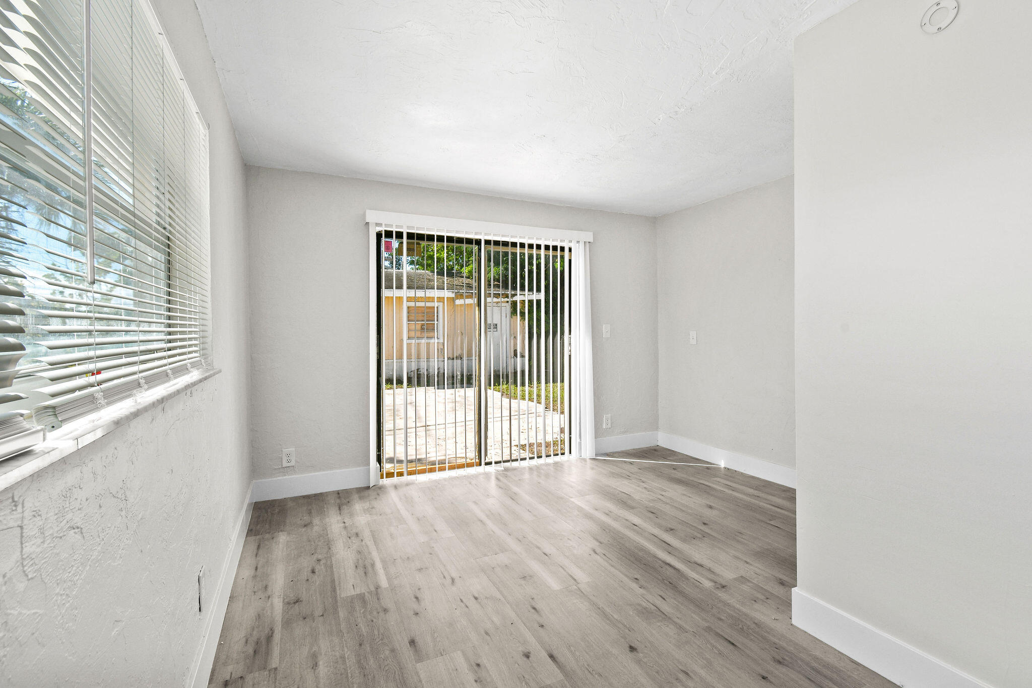 1301 West 25th Street Riviera Beach, FL 33404 - Photo 22 of 34 a view of an empty room with wooden floor and a window