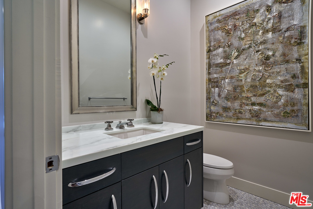 11622 Addison Street Valley Village, CA 91601 - Photo 24 of 39 a bathroom with a granite countertop sink a toilet and a mirror