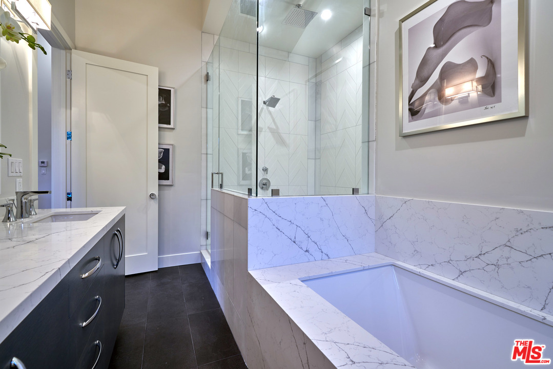 11622 Addison Street Valley Village, CA 91601 - Photo 32 of 39 a bathroom with a tub a sink and glass door