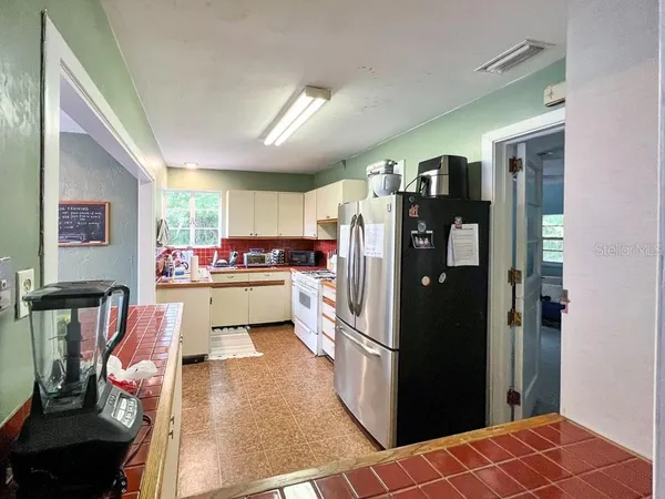 a kitchen with stainless steel appliances kitchen island granite countertop a refrigerator and a sink
