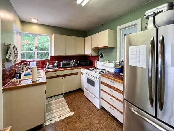 a kitchen with a refrigerator sink and cabinets