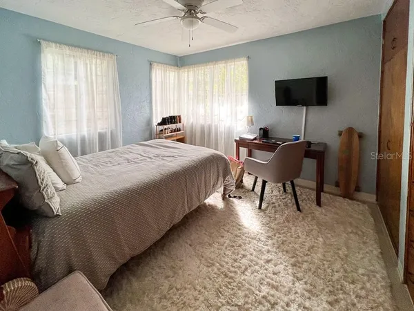 a bedroom with a bed a chair and a chandelier