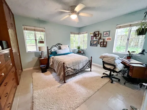 a bedroom with a bed gym equipment and a large window