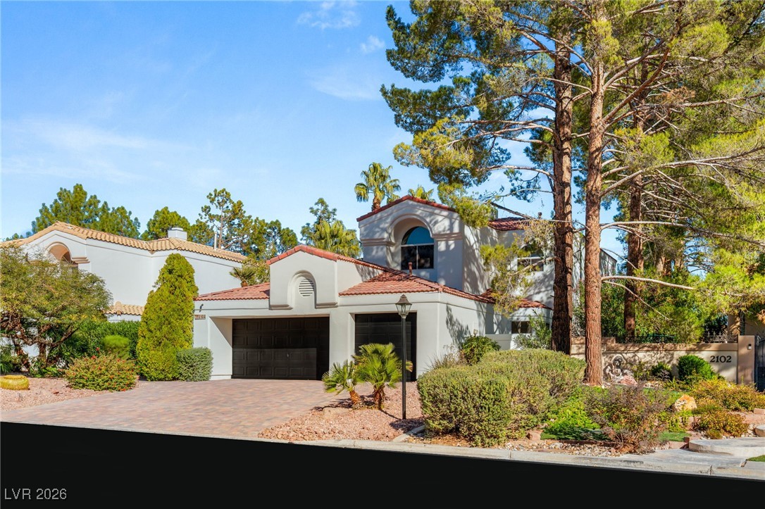 Mediterranean / spanish house with stucco siding, decorative driveway, and a tiled roof