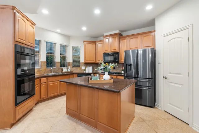 a kitchen with stainless steel appliances granite countertop a refrigerator and a sink
