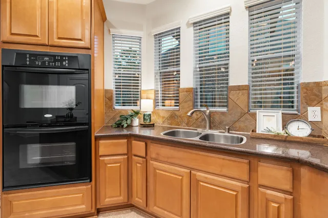 a kitchen with granite countertop cabinets stainless steel appliances a sink and a window