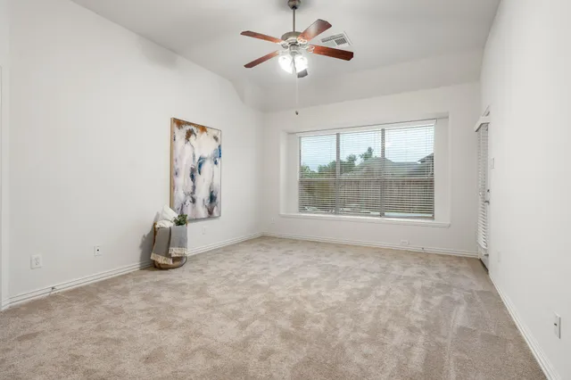an empty room with windows and fan
