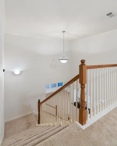 a view of staircase with railing and white walls