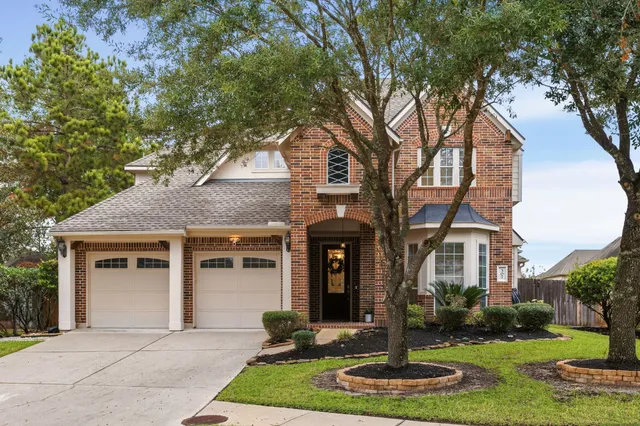 a front view of a house with yard and green space