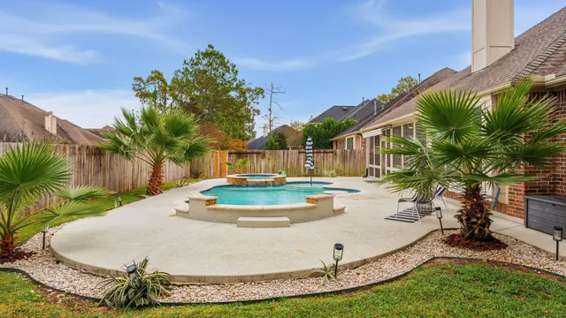 a view of a backyard with table and chairs potted plants and wooden fence