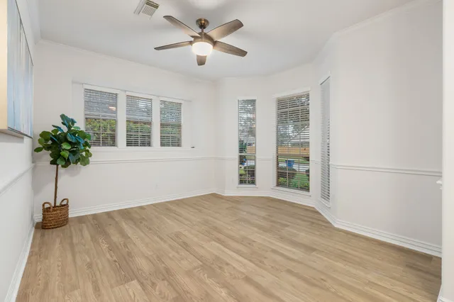 a view of an empty room with a window and wooden floor