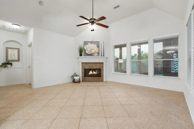 a view of an empty room with a fireplace and a window