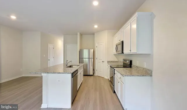 a kitchen with granite countertop a sink stove and refrigerator