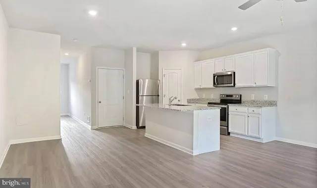a kitchen with a refrigerator and a stove top oven