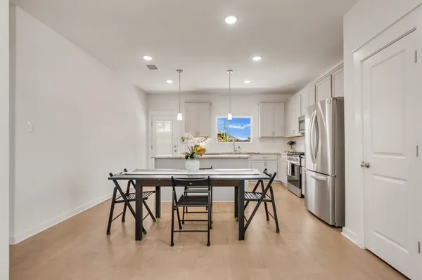 a kitchen with white cabinets and appliances