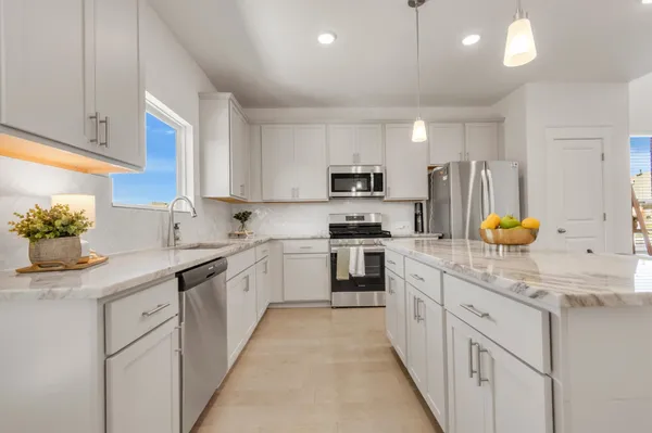 a kitchen with stainless steel appliances granite countertop a sink and a stove