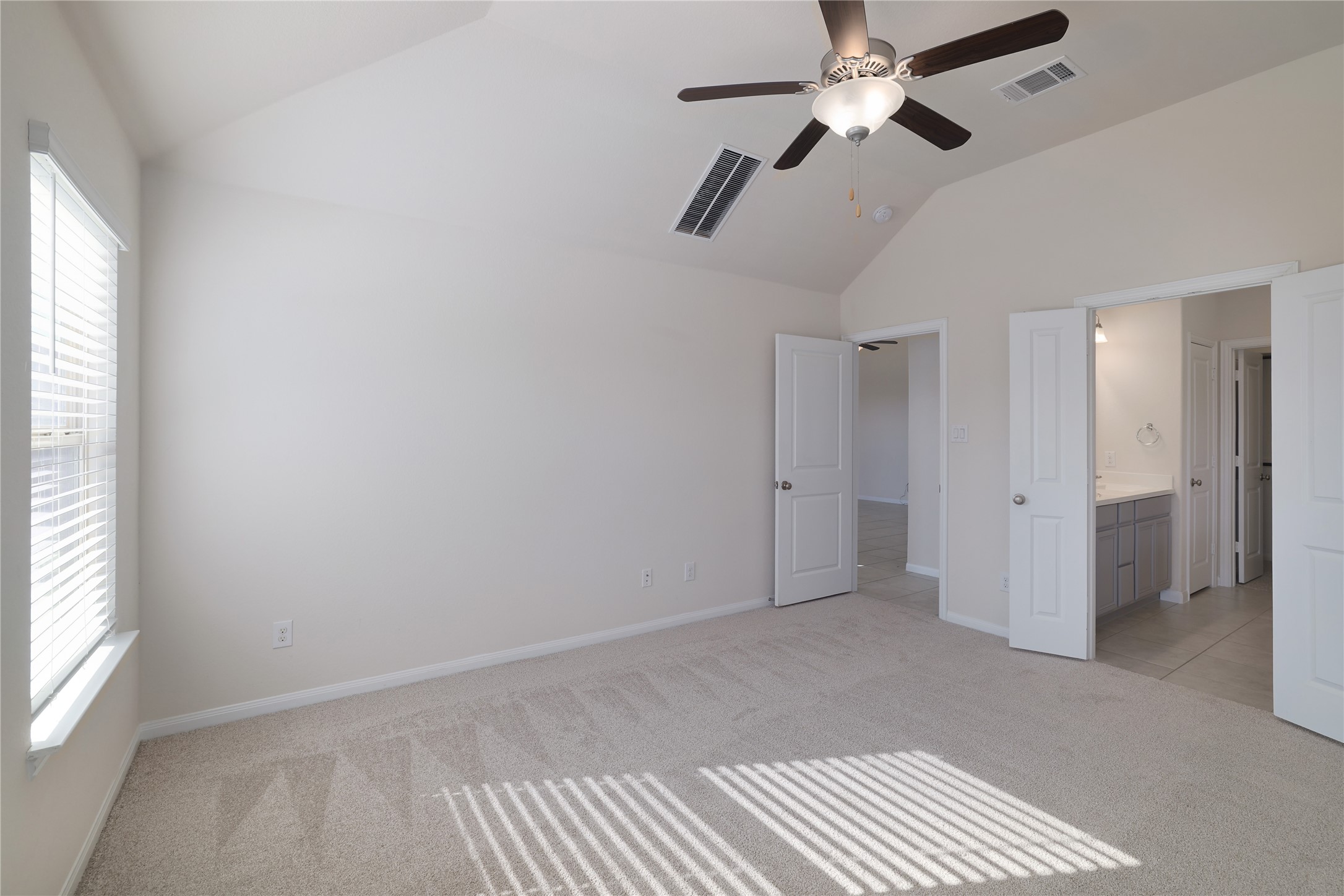 3341 Pauling Loop Round Rock, TX 78665 - Photo 17 of 40 Master bedroom with lofted ceiling, new carpet, ceiling fan, and ensuite bath