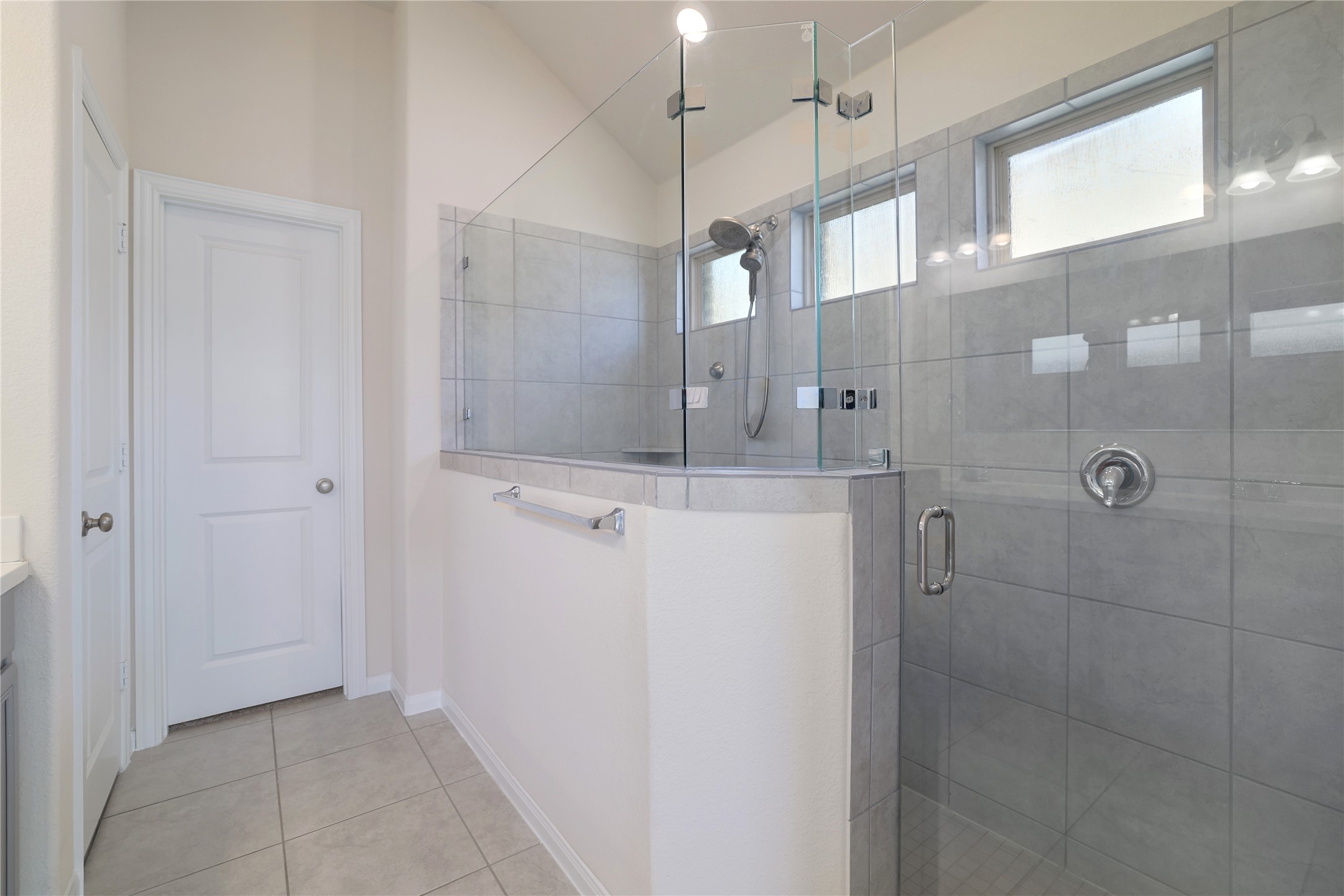 3341 Pauling Loop Round Rock, TX 78665 - Photo 19 of 40 Bathroom featuring a shower stall, vanity, light tile patterned floors, and lofted ceiling