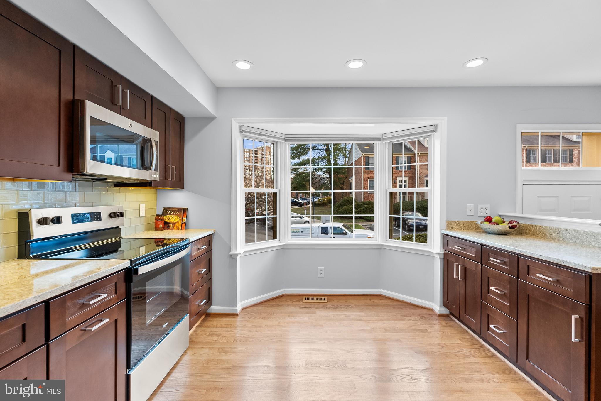 5465 Grove Ridge Way, Unit 123 Rockville, MD 20852 - Photo 11 of 39 a kitchen with stainless steel appliances granite countertop a stove and a sink