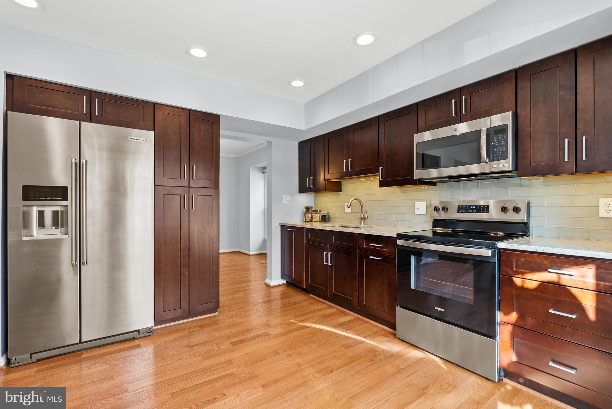5465 Grove Ridge Way, Unit 123 Rockville, MD 20852 - Photo 13 of 39 a large kitchen with stainless steel appliances granite countertop a stove a refrigerator and a microwave