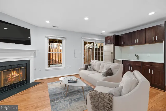 a living room with furniture a flat screen tv and a fireplace