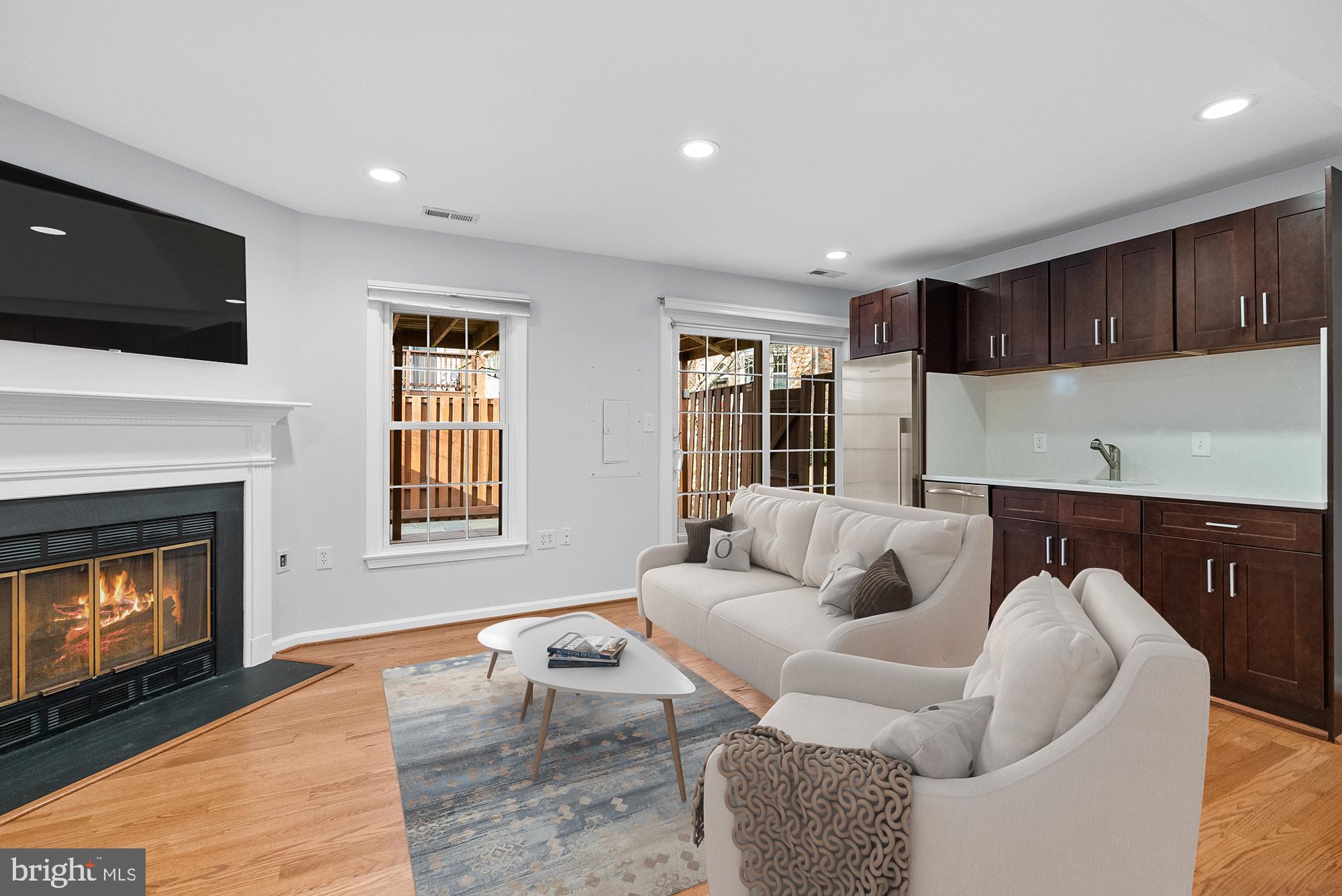 5465 Grove Ridge Way, Unit 123 Rockville, MD 20852 - Photo 24 of 39 a living room with furniture a flat screen tv and a fireplace