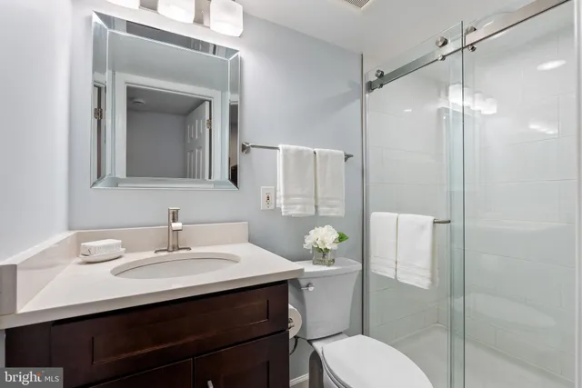 a bathroom with a sink toilet vanity and shower