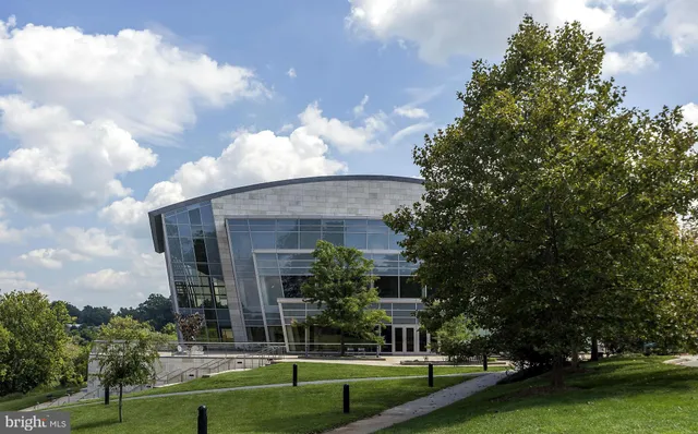 a view of a big building with big yard and large trees
