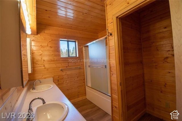 1129 Ponderosa Road, Unit 40 Hatch, UT 84735 - Photo 22 of 47 Wood-paneled interior featuring a double vanity with integrated sinks, a built-in shower with a frosted glass enclosure, and a window