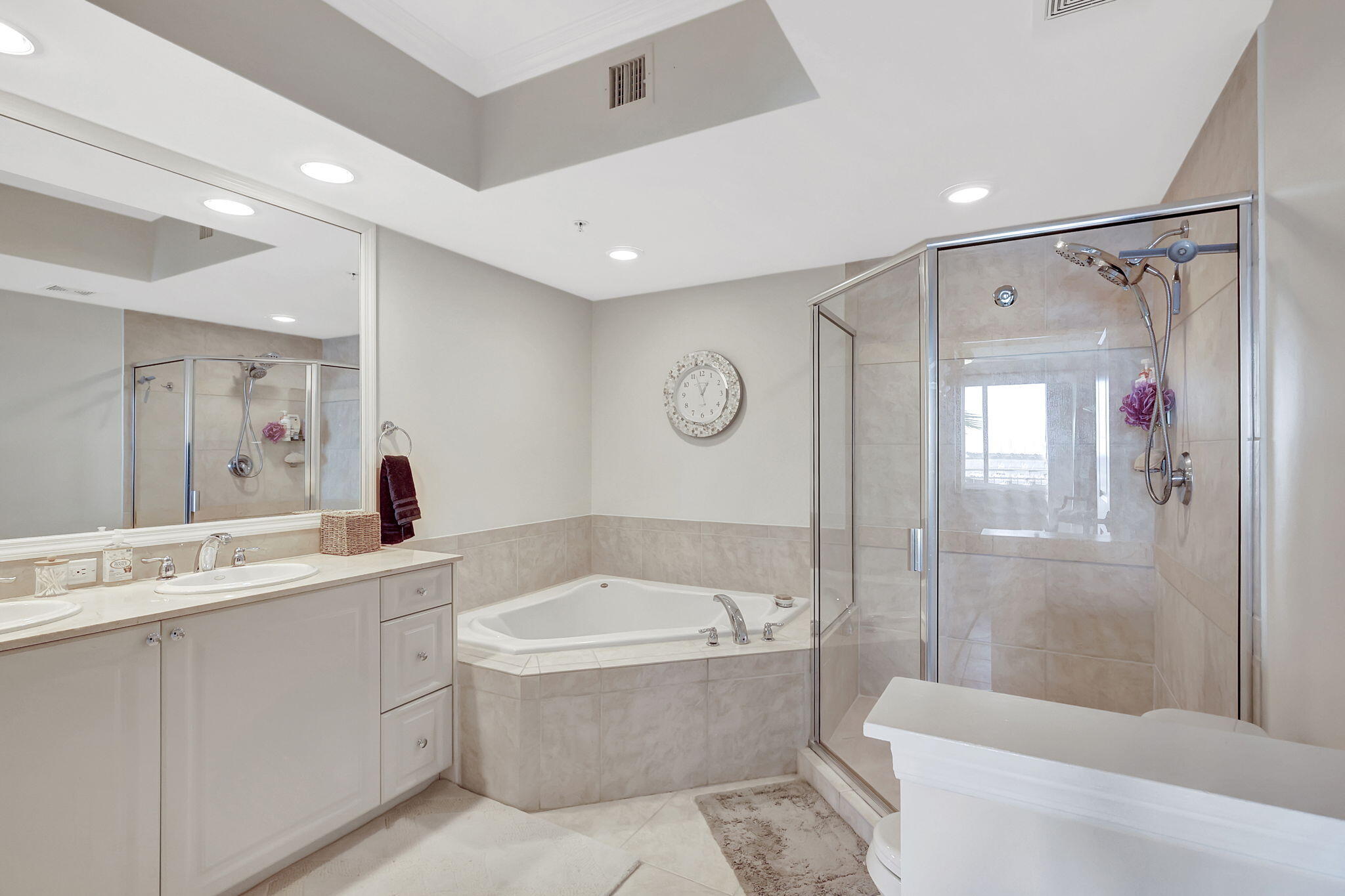 775 Northwest Flagler Avenue, Unit 401 Stuart, FL 34994 - Photo 26 of 56 a bathroom with a bathtub shower sink vanity mirror and toilet