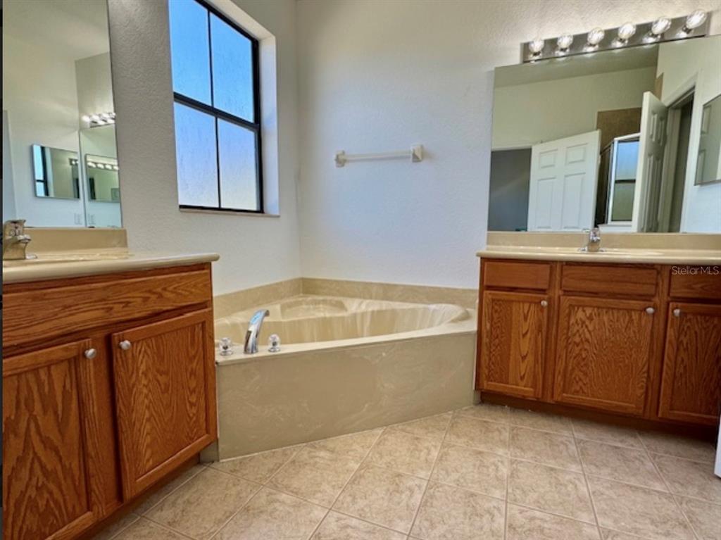 3489 Allegra Circle St. Cloud, FL 34772 - Photo 11 of 29 a bathroom with a tub sink and mirror