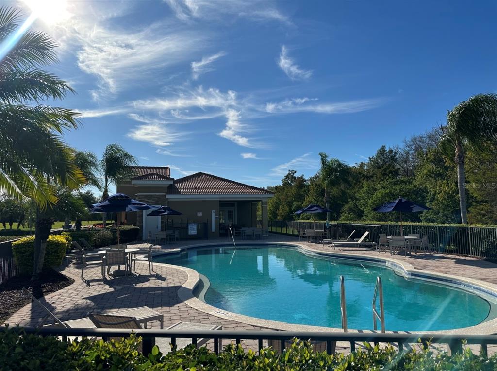 3489 Allegra Circle St. Cloud, FL 34772 - Photo 25 of 29 a view of a swimming pool with a table and chairs under an umbrella