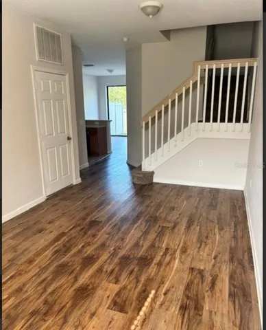 a view of a hallway with wooden floor and windows