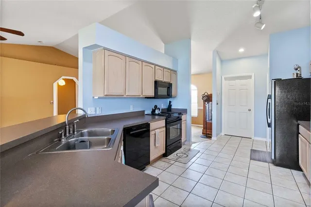 a kitchen with a sink a refrigerator and cabinets