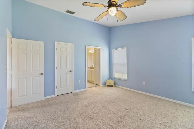 an empty room with a fan and a chandelier fan
