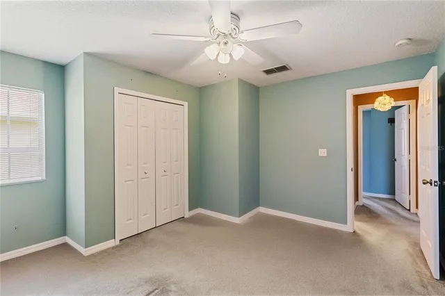 a view of a big room with closet and a chandelier fan