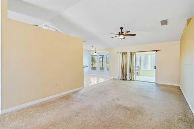 an empty room with closet and a ceiling fan
