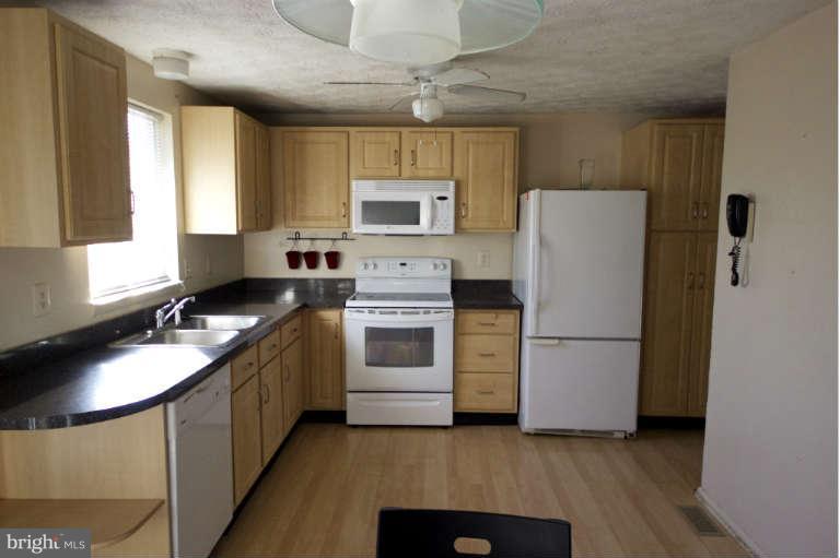 522 Fuselage Avenue Baltimore, MD 21221 - Photo 5 of 16 a kitchen with a sink a stove and refrigerator