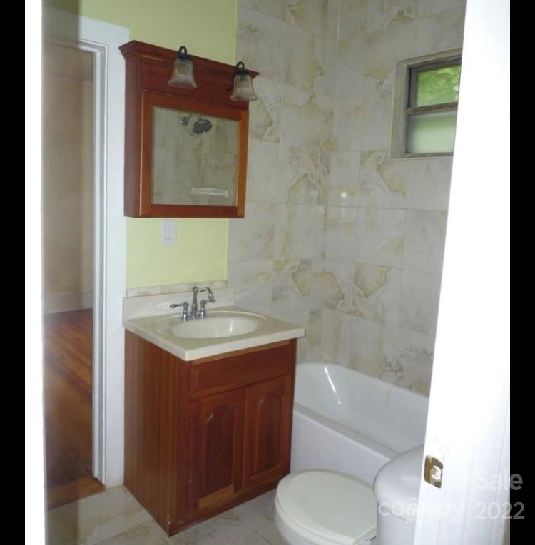 335 South Torrence Street Charlotte, NC 28204 - Photo 6 of 6 a bathroom with a granite countertop toilet a sink and mirror