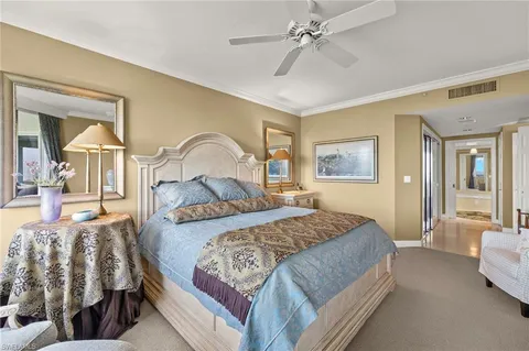 a bedroom with a large bed and a chandelier