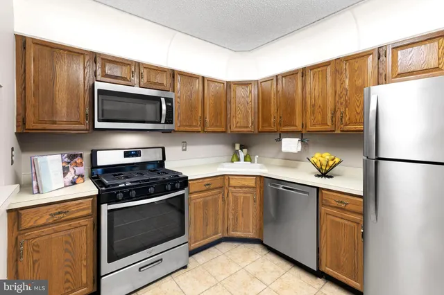 a kitchen with granite countertop a refrigerator stove and microwave