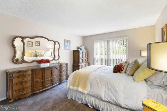 a bedroom with a bed a dresser and mirror