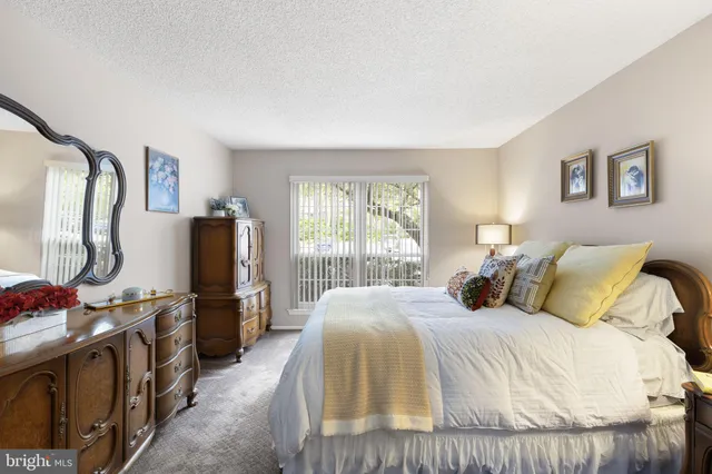 a bedroom with a bed and a flat tv screen on the dresser