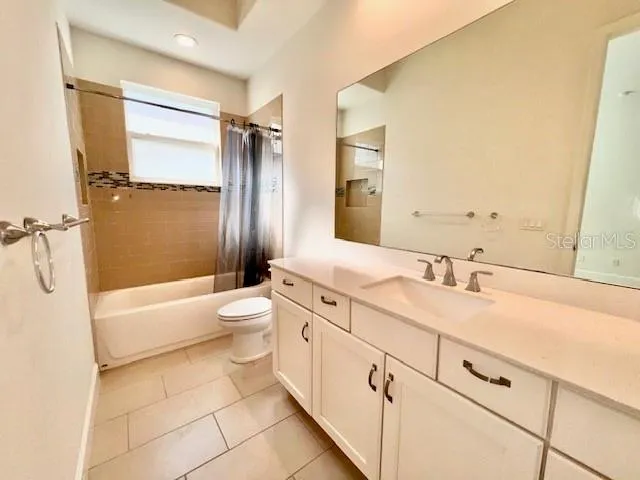 a spacious bathroom with a double vanity sink toilet mirror and bathtub